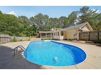 Backyard pool with concrete surround and mature trees providing ample shade and privacy at 19 Margrit Ct, Stockbridge, GA 30281