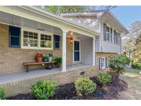 Charming brick home featuring a welcoming front porch with flower decor and colorful flowerpots at 3521 Eaglerock Dr, Atlanta, GA 30340