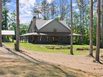 Charming home featuring a welcoming wrap-around porch and lush, green landscaping at 3805 Carder Ln, Cumming, GA 30028
