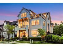 Inviting three-story home featuring dual balconies and rooftop deck, complemented by manicured landscaping at 4550 Lois Se St, Smyrna, GA 30080