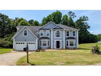 Charming two-story home featuring a two-car garage and a well-manicured lawn at 6231 Waterton Way, Lithonia, GA 30058