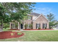 Charming brick two-story home with manicured lawn and black shutters at 2023 Arbor Springs Way, Buford, GA 30519