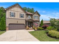 Charming two-story home featuring manicured lawn, two-car garage, and decorative shutters, complete with beautiful landscaping at 1645 Horseshoe Creek Ln, Cumming, GA 30041
