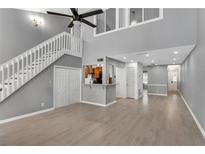 Bright living room boasts hardwood floors, a staircase, and neutral paint, with a glimpse of the kitchen area at 4234 Stillwater Dr, Duluth, GA 30096
