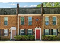 Charming townhome featuring a brick facade, trimmed windows, and a well-maintained front garden at 135 N North River Dr, Atlanta, GA 30350