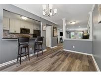 Stylish dining area featuring hardwood floors, gray walls, and an eat-in bar looking into the kitchen at 135 N North River Dr # G, Atlanta, GA 30350