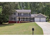 Charming two-story home with gray siding, black shutters, and a welcoming front porch at 4261 Vineyard Trl, Snellville, GA 30039