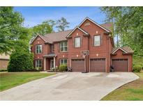 Impressive brick home with a three-car garage and well-manicured lawn in a desirable neighborhood at 4960 Tadmore Ln, Lithonia, GA 30038