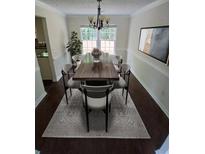 Bright dining room featuring modern chandelier, a wood table, and stylish gray chairs and rug at 5320 Taylor Rd, Alpharetta, GA 30022