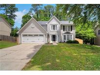 Charming two-story home with a well-manicured lawn and attached two-car garage, creating a welcoming curb appeal at 5320 Taylor Rd, Alpharetta, GA 30022