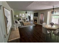 Spacious living room featuring a fireplace, hardwood floors, and ample natural light at 5320 Taylor Rd, Alpharetta, GA 30022