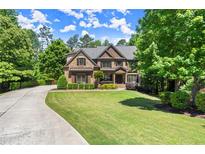 Stunning brick home with lush landscaping, sprawling green lawn, and long private driveway at 2660 Burnt Hickory Dr, Cumming, GA 30028