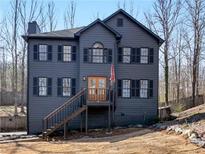 Charming two-story home with a dark exterior, black shutters, and a welcoming front porch at 526 Lakeside Dr, Hiram, GA 30141