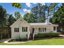 Charming one-story home with a covered front porch, a well-maintained lawn, and mature trees at 6637 Oak Farm Se Dr, Acworth, GA 30102