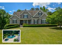 Charming traditional home boasts a lush front lawn and mature landscaping, creating a welcoming curb appeal at 3740 Duckcove Way, Cumming, GA 30041