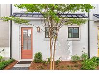 Charming home entrance with a salmon-colored door and beautifully landscaped front yard at 4462 Dandelion Ln, Atlanta, GA 30342