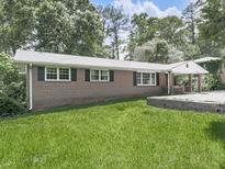 Charming brick home featuring a well-maintained lawn and inviting front porch at 3163 Old 41 Nw Hwy, Kennesaw, GA 30144