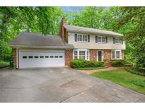 Charming two-story home with a brick and light yellow facade, attached garage, and a well-maintained lawn at 3999 Saint Clair Ne Ct, Brookhaven, GA 30319