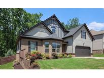 Charming two-story home with manicured lawn, brick accents, and a two-car garage at 6140 Stillwood Ln, Cumming, GA 30041