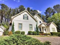 Charming two-story home features a well-manicured lawn, lush greenery, and neutral siding at 122 Griffin Way, Canton, GA 30115