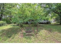 Charming home with lush lawn, mature trees, and stone steps leading to the front porch at 191 White Oak Church Rd, Dallas, GA 30157