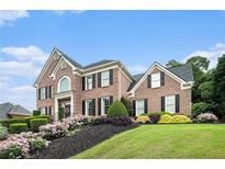 Beautiful brick home with manicured lawn and colorful landscaping at 2258 Bright Water Dr, Snellville, GA 30078