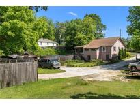 Charming home featuring a lush, green lawn and mature trees providing ample shade and a serene atmosphere at 2667 Peyton Nw Rd, Atlanta, GA 30318