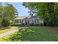 Charming single-story home features a well-manicured lawn, a stone walkway, and a welcoming red front door at 382 Lofton Nw Rd, Atlanta, GA 30309
