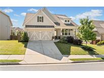 Charming two-story home boasts a manicured lawn and a welcoming front porch at 410 Gardens Of Harmony Dr, Canton, GA 30115