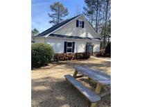 Exterior view of the community pool house and picnic benches on a sunny day at 748 Great Oak Pl, Villa Rica, GA 30180