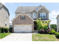 Charming two-story home featuring a brick and stone facade, a two-car garage, and a well-maintained lawn at 5888 Cobblestone Creek Cir, Mableton, GA 30126