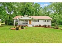 Charming single-story home with a well-maintained lawn and inviting front porch at 211 Caboose Ln, Woodstock, GA 30189