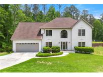 Charming stucco home with a well-manicured lawn and attached two-car garage at 3060 Robertswood Dr, Powder Springs, GA 30127