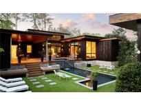 This modern home features a luxurious backyard with a sleek pool, waterfall, and ample seating at 3740 Powers Ferry Nw Rd, Atlanta, GA 30342