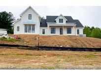 Elegant two-story home featuring a modern farmhouse design and a covered porch entry at 933 Mount Carmel Church Ln, Canton, GA 30114