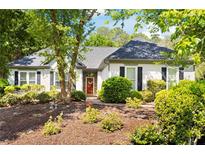 Charming single-story home featuring a well-manicured front yard with lush landscaping and a welcoming red front door at 401 Azalea Cv, Canton, GA 30114