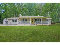 Charming ranch-style home with a covered front porch and a spacious, well-manicured lawn at 9955 Rivertown Rd, Fairburn, GA 30213