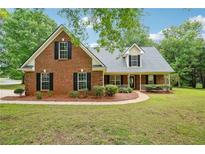 Charming brick home with a manicured lawn and inviting front porch, perfect for relaxing and enjoying the neighborhood at 10 Hollow Ct, Covington, GA 30016