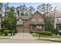 Charming brick home featuring a well-manicured lawn, attached two-car garage, and inviting covered front porch at 436 Barnett St, Woodstock, GA 30188