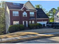 Charming two-story brick home featuring solar panels, a two-car garage, and well-maintained landscaping at 230 Shiver Blvd, Covington, GA 30016