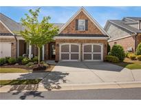 Charming brick home featuring a two-car garage and manicured landscaping, creating an inviting curb appeal at 5850 Overlook Rdg, Suwanee, GA 30024