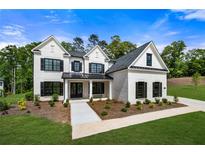 Stunning two-story white brick home featuring black window shutters and a beautifully landscaped front yard at 17145 River Overlook Dr, Roswell, GA 30075