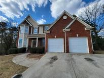 Charming two-story home with a brick and siding exterior and a two-car garage at 1745 Collines Sw Ave, Atlanta, GA 30331