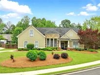 Charming single Gathering home with manicured front yard and a combination of siding and stone exterior finishes at 3174 Piney Woods Cir, Buford, GA 30519