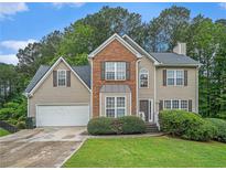Traditional two-story home featuring brick and siding with a well-manicured front lawn and an attached two-car garage at 3885 Weeping Willow Ln, Loganville, GA 30052