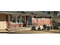 Traditional home with a welcoming front porch framed by decorative iron railings and brick accents at 1911 Rosewood Rd, Decatur, GA 30032