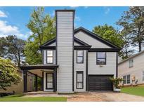 Charming two-story home featuring light gray siding, a tall chimney, and a single-car garage at 1050 Hampton Hill Ct, Lawrenceville, GA 30044