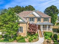 Beautiful two-story brick home with manicured landscaping and inviting front porch at 3456 Glen Mist Pl, Dacula, GA 30019