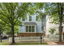 Charming two-story home with light blue siding, stone accents, and a white picket fence at 1560 Gilstrap Nw Ln, Atlanta, GA 30318