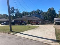 Wide shot of two-story home with mature trees and driveway; several cars visible at 2079 Bencal Se Dr, Atlanta, GA 30316